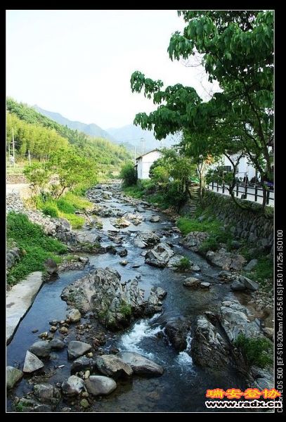 民居前有一条清澈的溪流。