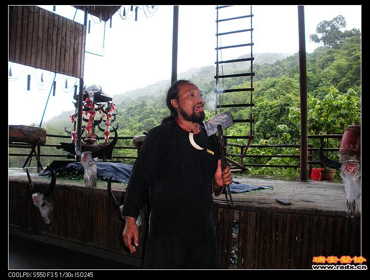 村长在表演用舌头舔高温铁。